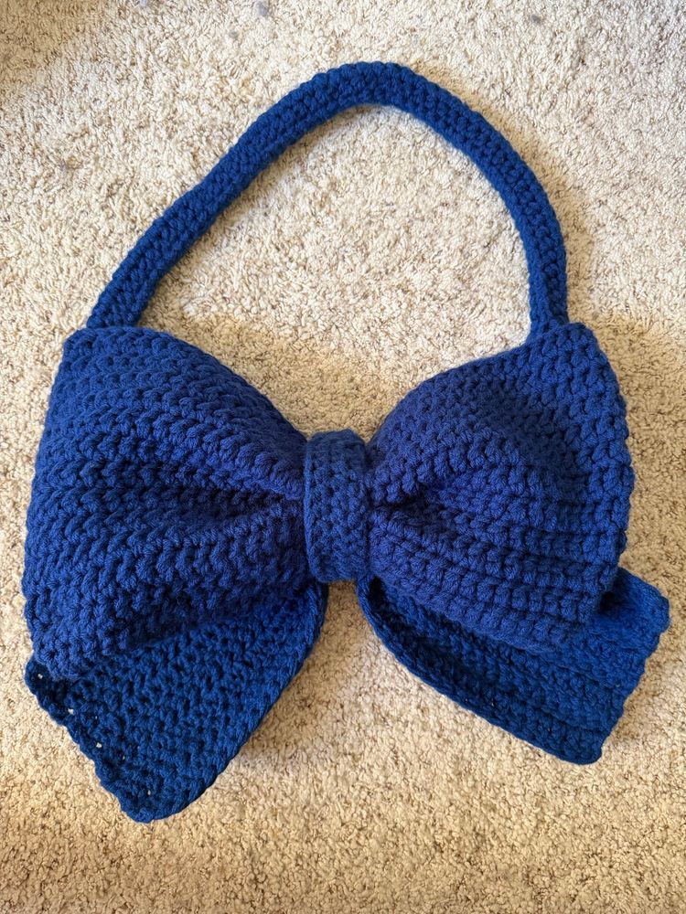 A crochet bow with a strap in navy blue
