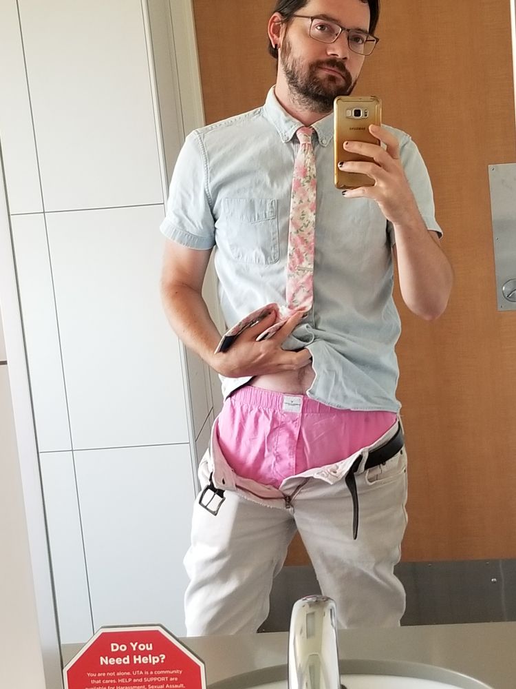 A selfie of me in my work bathroom mirror. I'm wearing a tie and I'm showing off my boxers, which are hot pink 