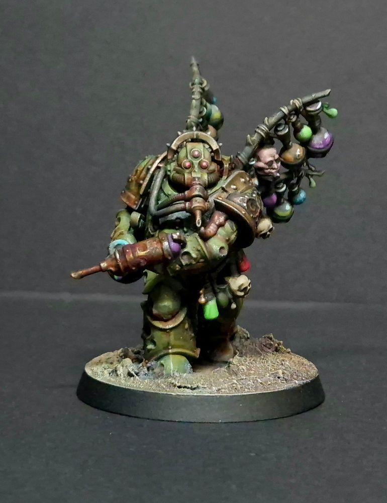 A rather grubby looking marine with a dirty syringe gun (?). He has the classic 3 eyes for nurgle and sports racks of chemical bottles on his back.