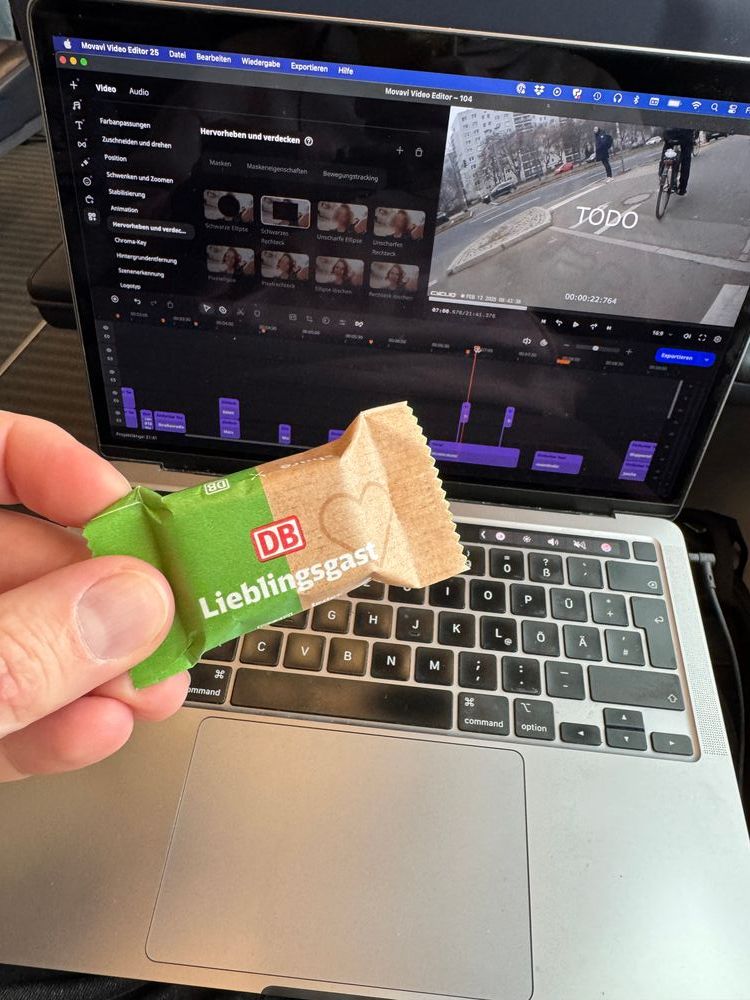 Hand hält schokolade "lieblingsgast" der DB vor einem Bildschirm mit Schnittprogram, auf dem Video kann man "TODO" sehen