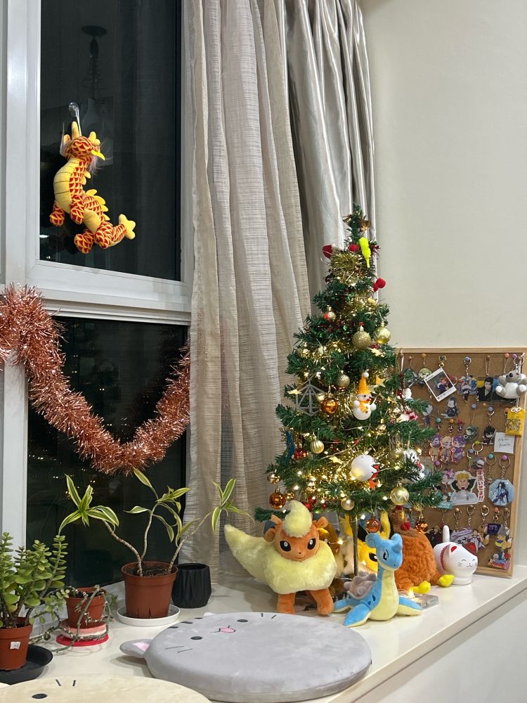 A picture of a bay window with a Christmas tree surrounded by Pokémon plushies