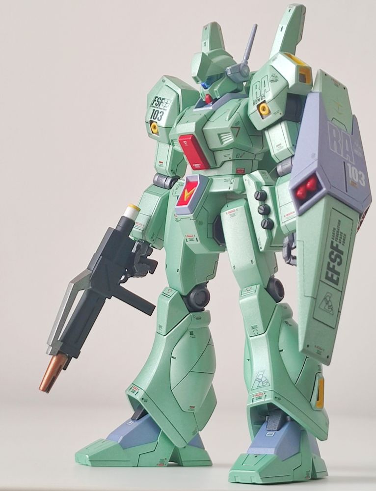 Gunpla au format High Grade du RGM-89 Jegan, mobile suit de l’univers Gundam apparu pour la première fois dans le film Mobile Suit Gundam: Char’s Counterattack. C'est une unité produite en masse par la Fédération Terrestre.
Sur la photo, le gunpla est orienté de 3/4, sa couleur principale est vert perle, il tient une mitraillette en main droite et un bouclier est suspendu à son bras gauche.
