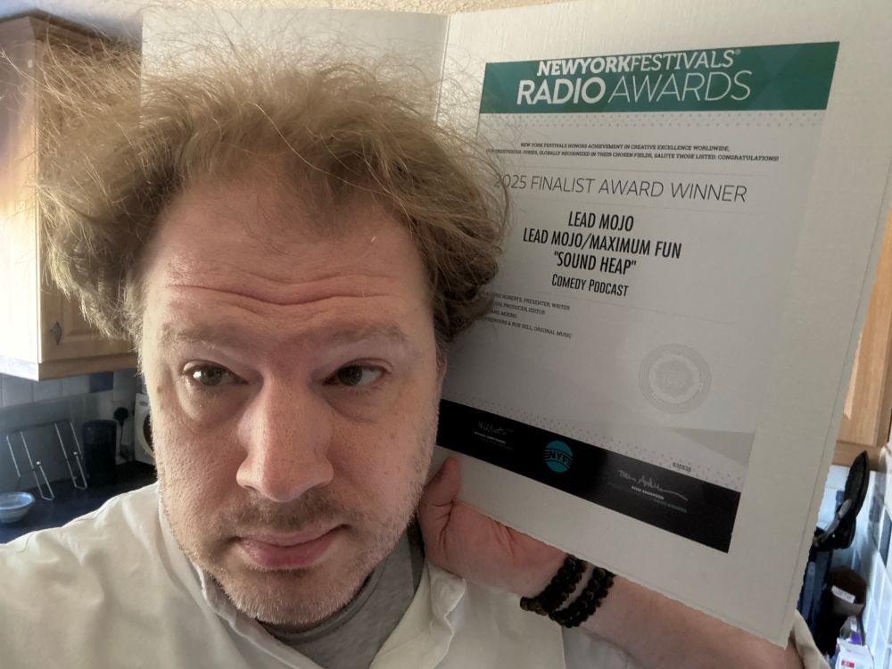 Ed Morrish holding up the certificate to his head so you can see it is an A4 sized certificate within a slightly larger cardboard frame