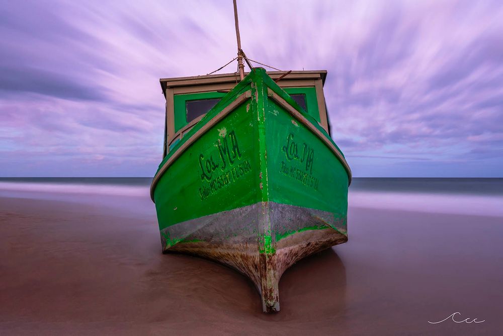 An old wooden boat washed ashore on the coastline of South Florida 