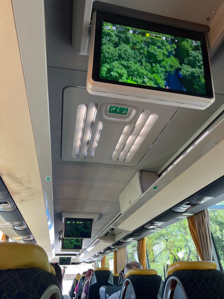 Watching Tour de France on multiple overhead screens on a coach
