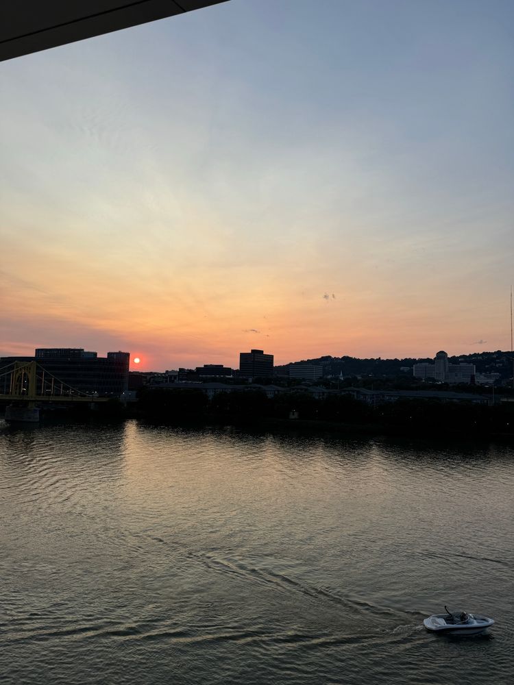 The sun setting over a river in Pittsburgh. 
