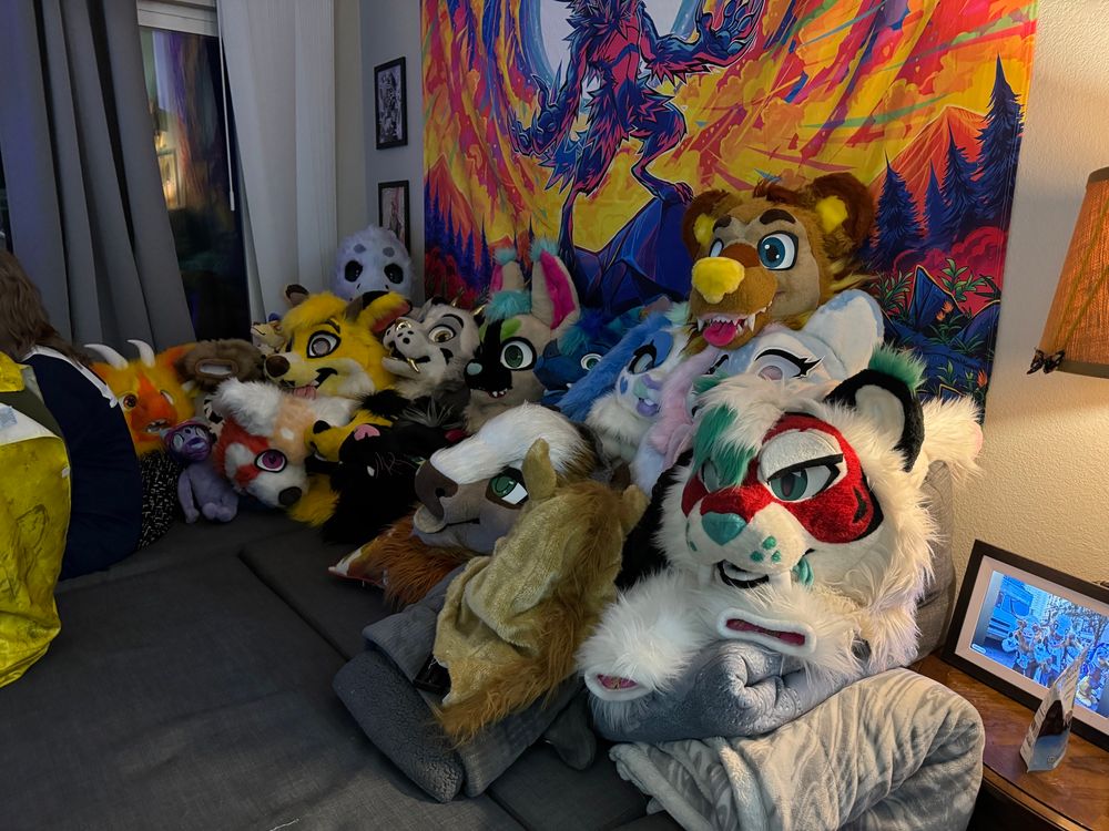 A couch full of fursuit heads. 