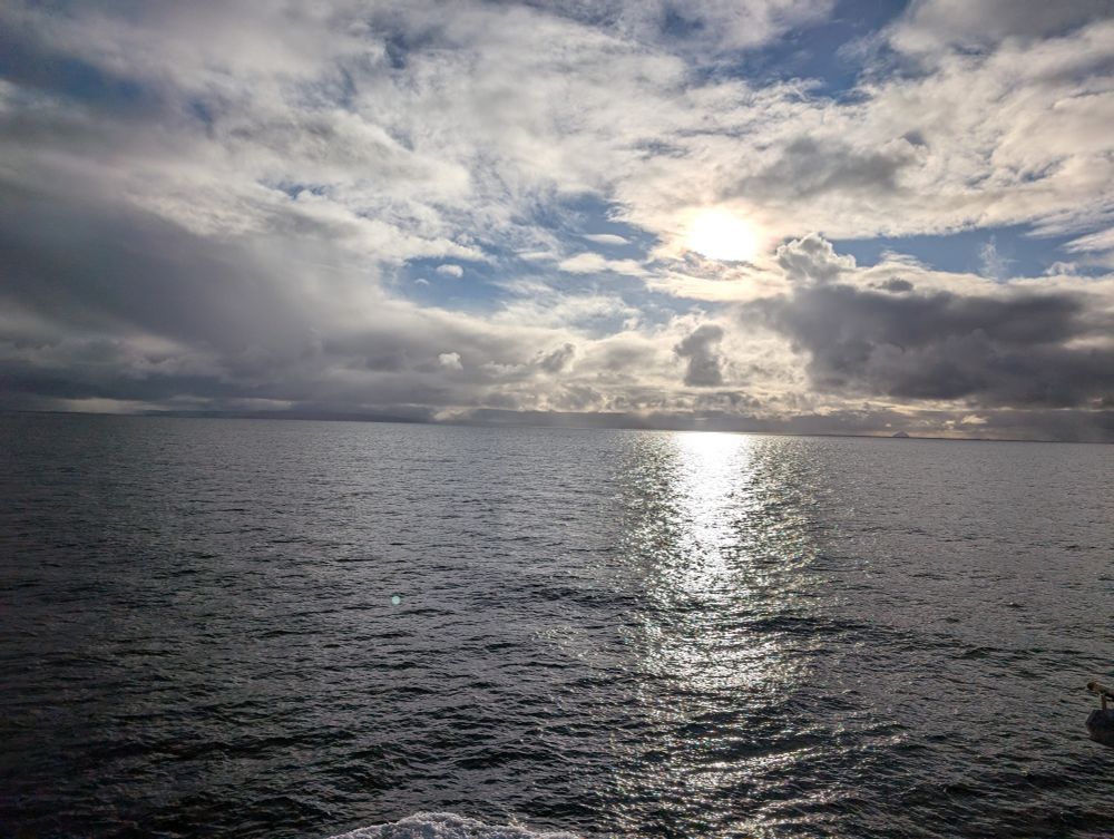 View of sea from Arran ferry. Sunlight on grey water 