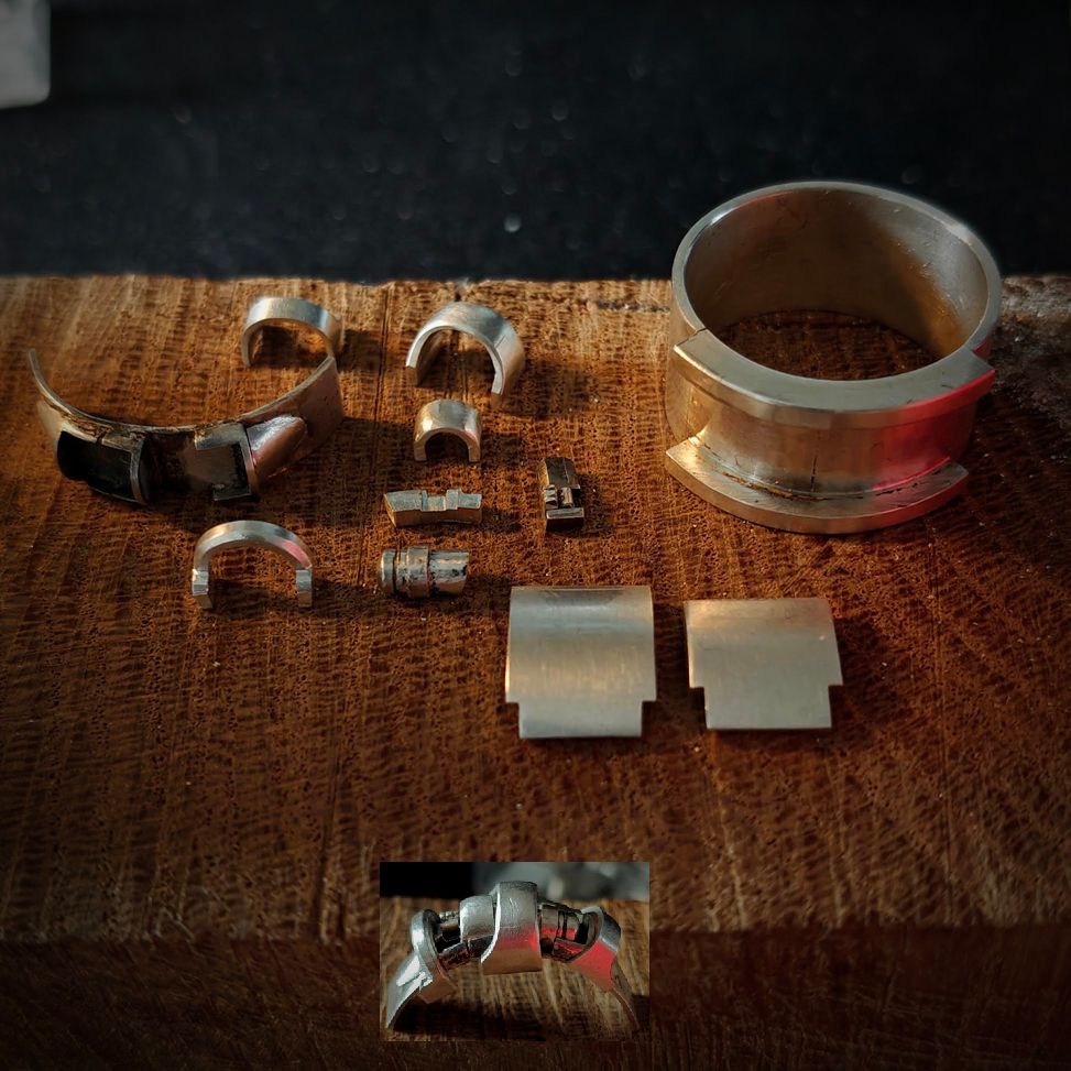 Tout un tas de petits éléments en argent. Il y en a 22 en tout, certains sont déjà soudés. Tout s’emboîte et se met à sa petite place. 
Il reste à nettoyer tout ça, assembler, souder ce qui doit être soudé, riveter ce qui doit être riveté et puis voilà.
J'ai mis une petite photo d'un montage-pour-voir de la partie centrale, qui viendra se placer entre les deux trucs plus épais de l'anneau. 