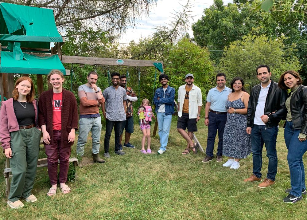 QuNB group picture against a backdrop of trees and a swingset.