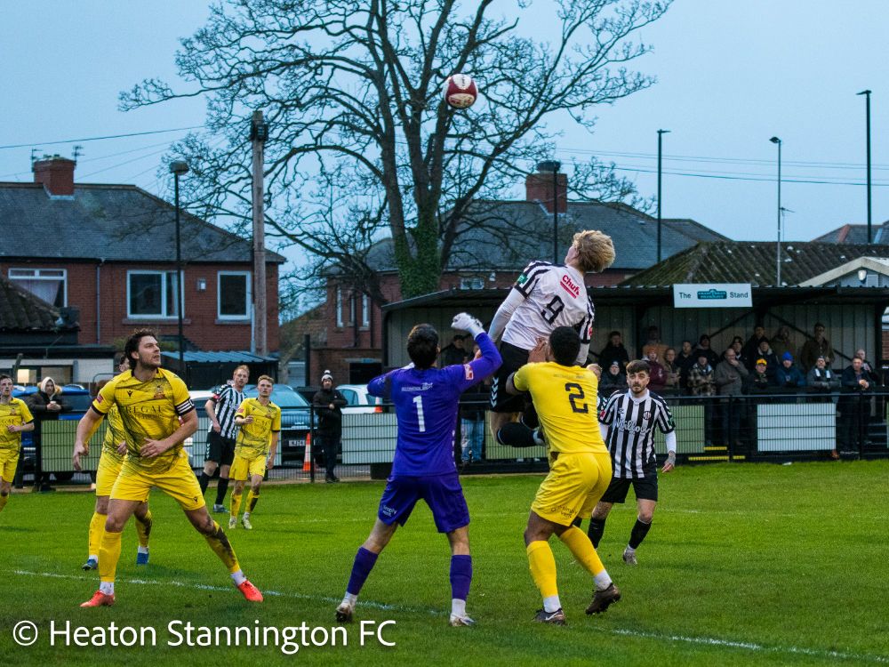 Footballers leaping to the ball. One of them is much higher than the others