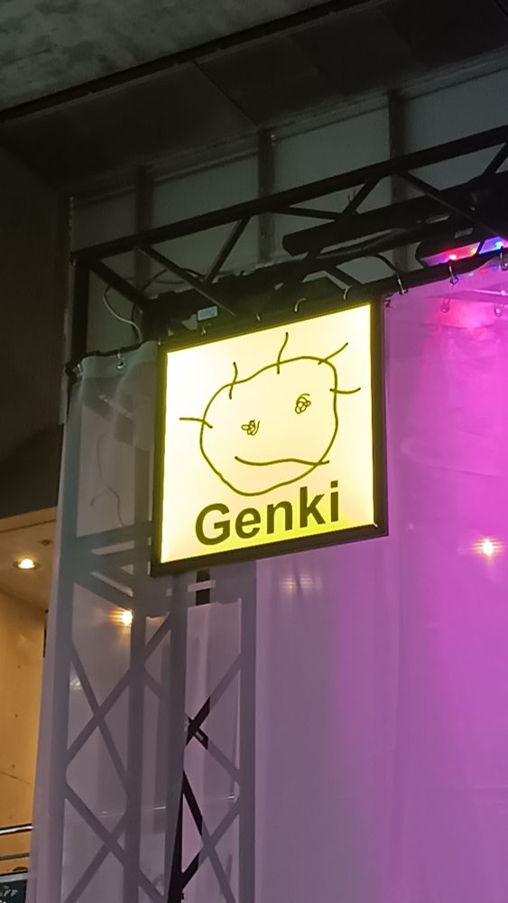 A yellow sign with a sickly looking childishly drawn face says 'genki"