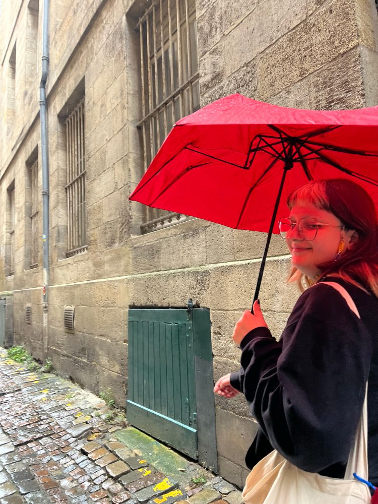 hadès beau gosse sous son parapluie rouge