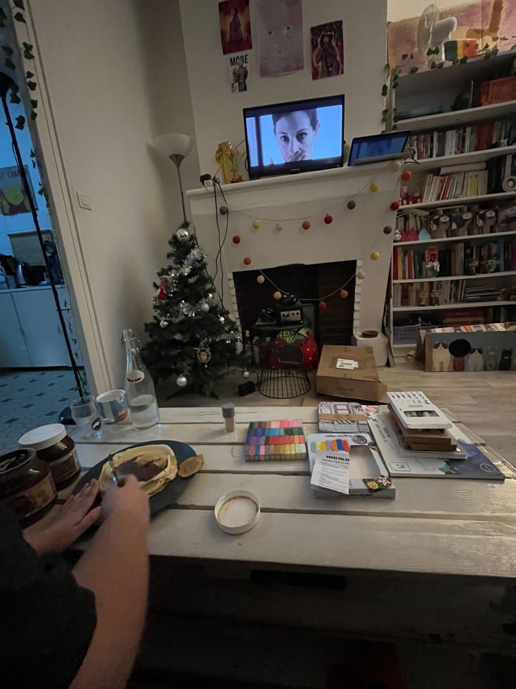 hadès qui tartine une crepe de chocolat devant notting hill, il y a des activités manuelles sur la table