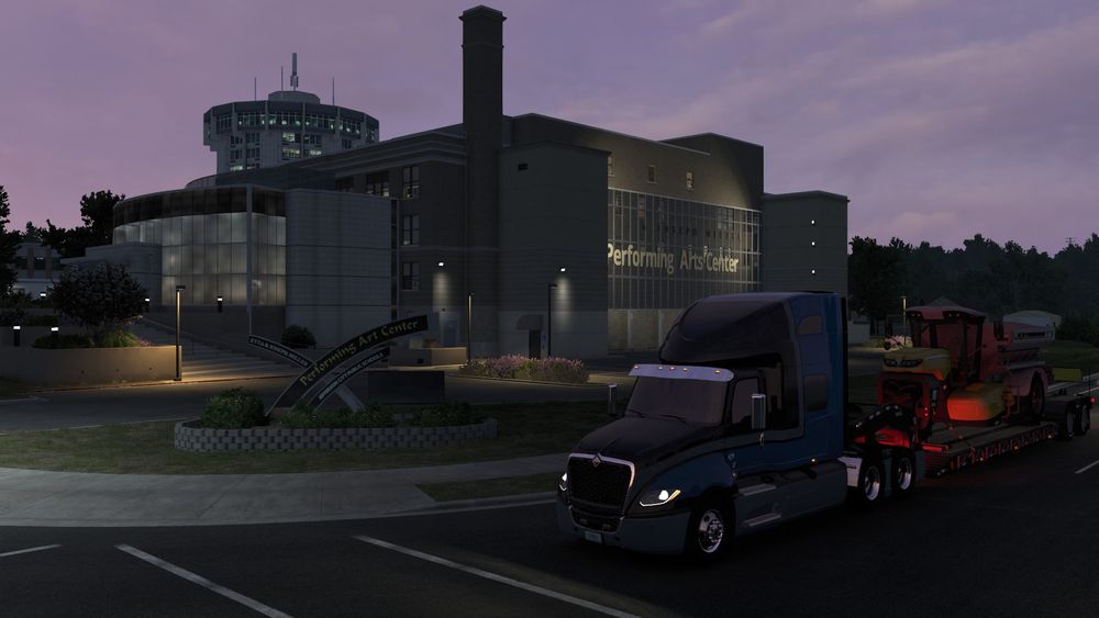 Frontal view of the truck near the Performing Arts Center in Jefferson City. The sky is shaded in deep violet with dramatic white clouds. The building’s modern architecture stands out in the background.