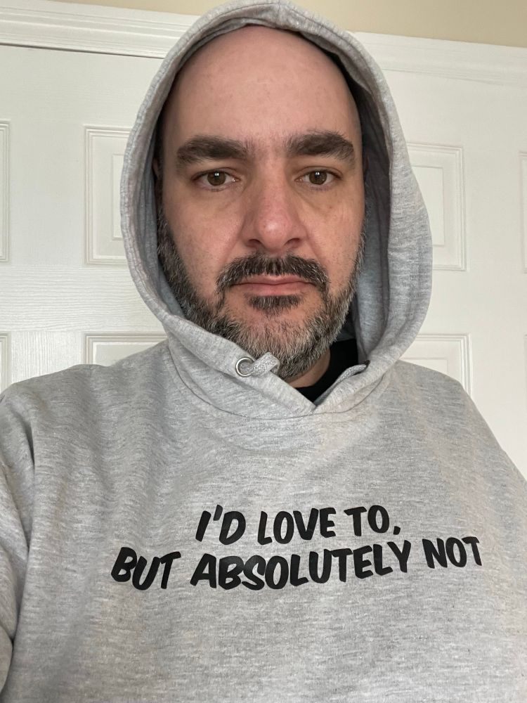 The poster, a bearded white man, is wearing a grey hoodie with the phrase “I’d love to, but absolutely not” across the chest.