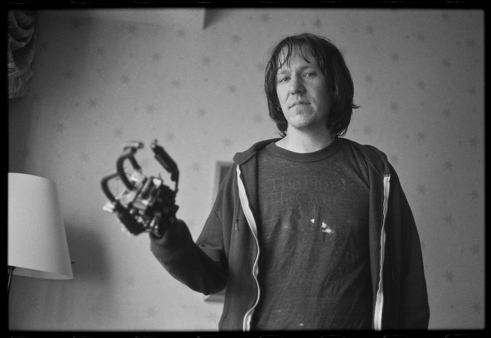 Elliott Smith with a robot hand from the Strange Parallel short.