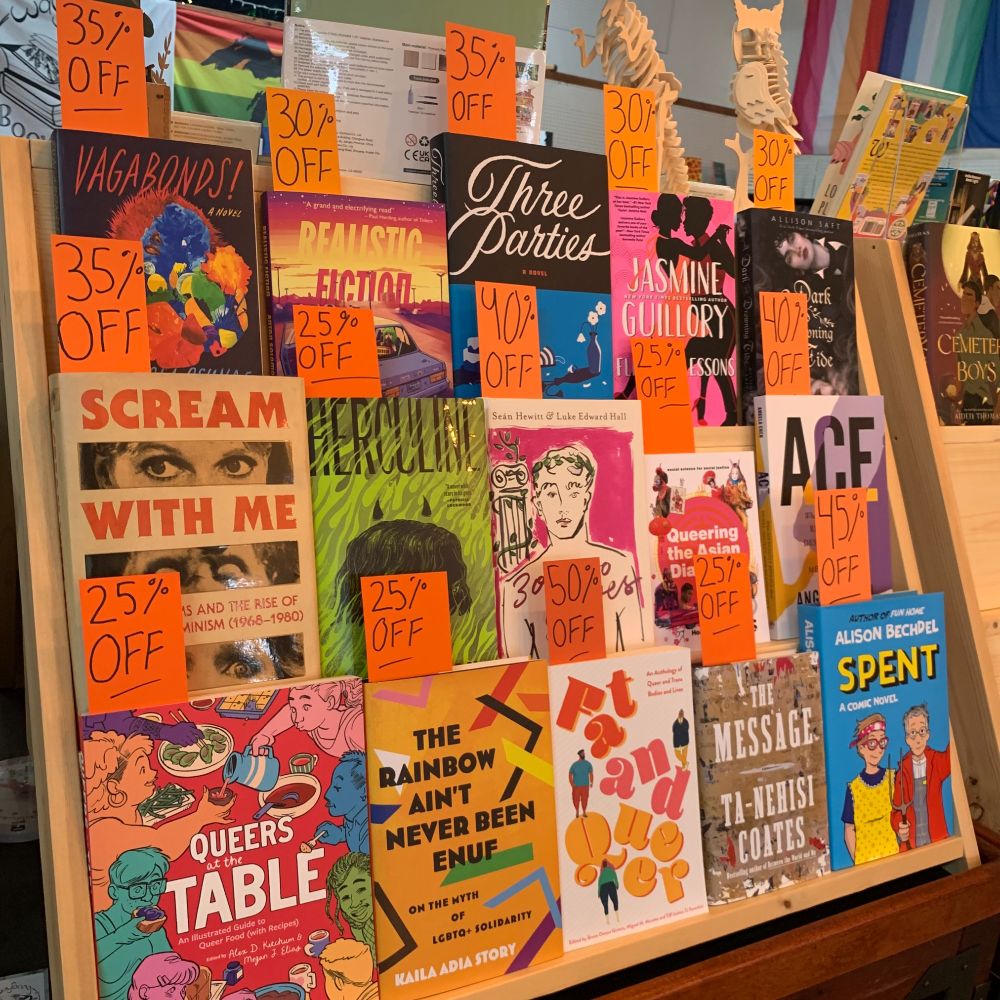 A selection of face-out books at Wayfaring Booksellers. Each book has a different bookmark in it with a discount ranging from 25% off to 50% off written in black Sharpie at the top. 