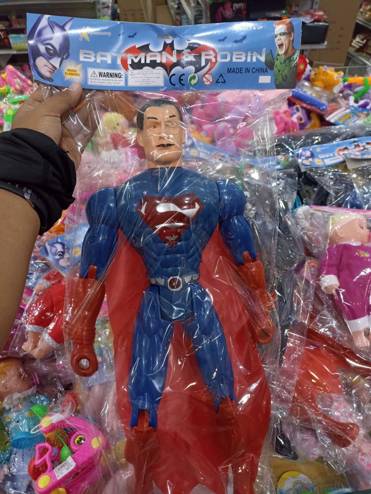 Á Mexican bootleg superman toy in clear, plastic bag packaging. The packaging is labeled Batman and Robin, and has a picture of Batman and The Riddler on it. The most super of supermen.