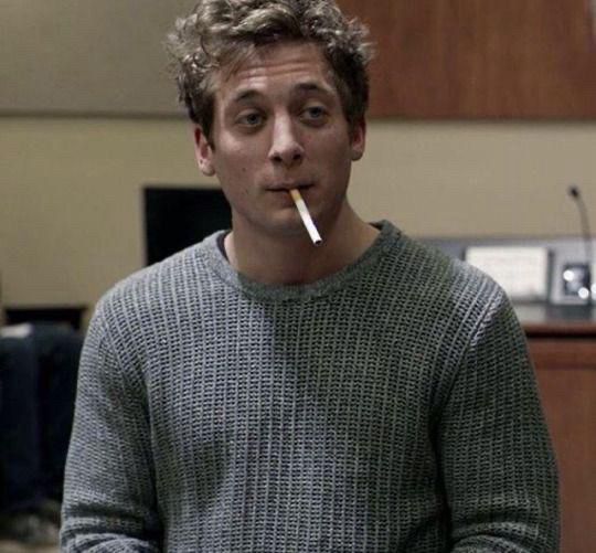 Jeremy Allen White as Lip Gallagher, one of many Gallaghers who try to save the family from Frank. Wearing gray sweater, cigarette dangling from his mouth, expressive eyes and slightly large but attractive nose. 
