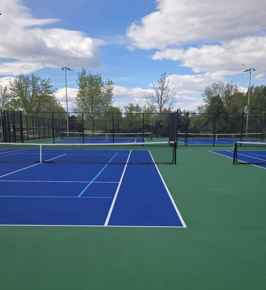 Blue and green tennis courts in a public park.
