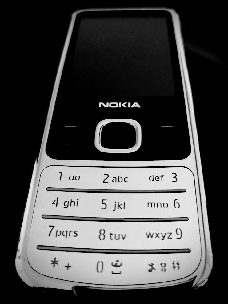 Blick auf ein Nokia 6700 Handy, Perspektive von unten nach oben. Bild in schwarzweiß.