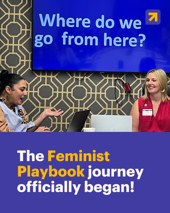 A two-part image showing a workshop in progress. The top half shows two women seated, one with her hands open, gesturing toward a large monitor displaying the question "Where do we go from here?". The bottom half of the image has a dark indigo-purple background with a large text overlay in white and yellow that reads, "The Feminist Playbook journey officially began!". The Women Deliver logo is in the top right corner of the image.