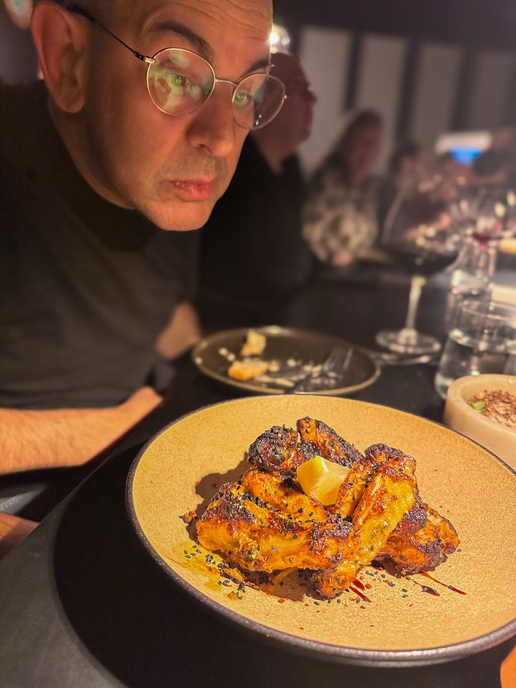 Simon staring at a plate of chicken wings 