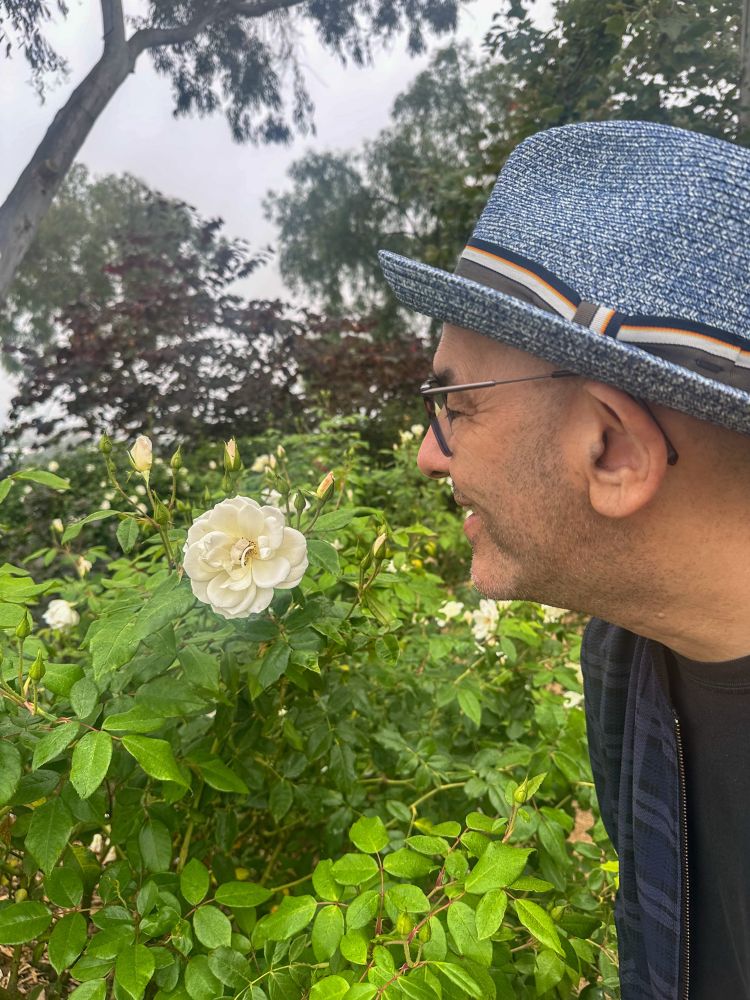 Simon smelling a white rose.