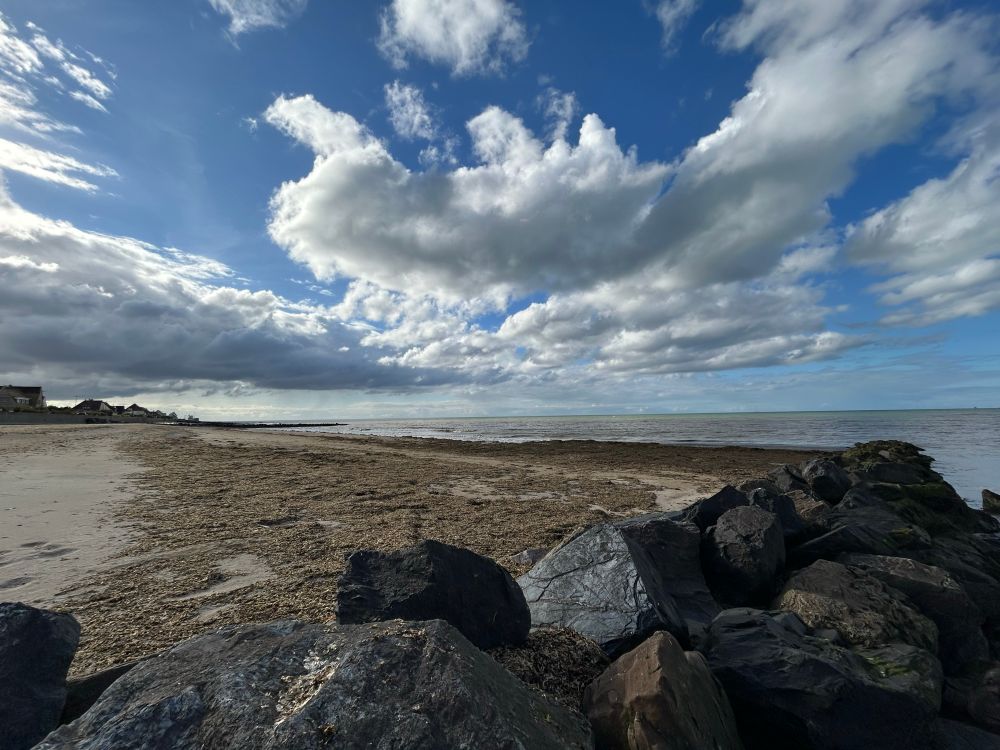 Steinbrocken, Sandstrand, Meer und Wolken