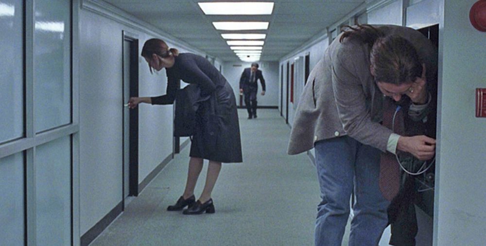 Screenshot from movie "Being John Malkovich" where employees work in offices with very low ceiling.