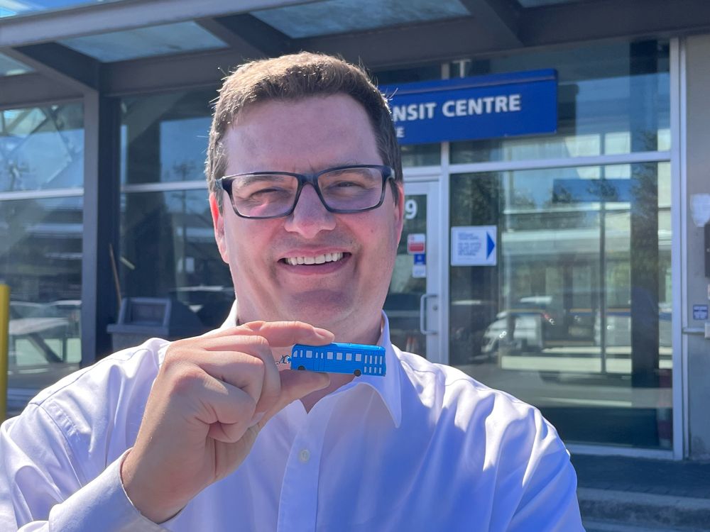Dan Coulter holds up a mini TransLink trolley 