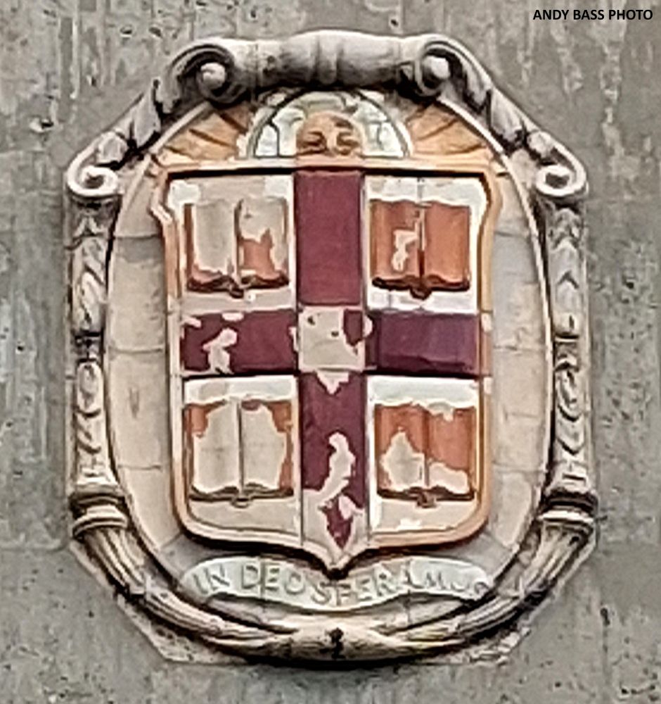 A cartouche with the coat of arms of Brown University adorns the top of the South Stand façade of Brown Stadium.  The coat of arms consists of a shield with a red cross and open books in each of the quadrants. The Latin motto "In Deo Speramus" (“In God We Hope”) is inscribed below the shield.