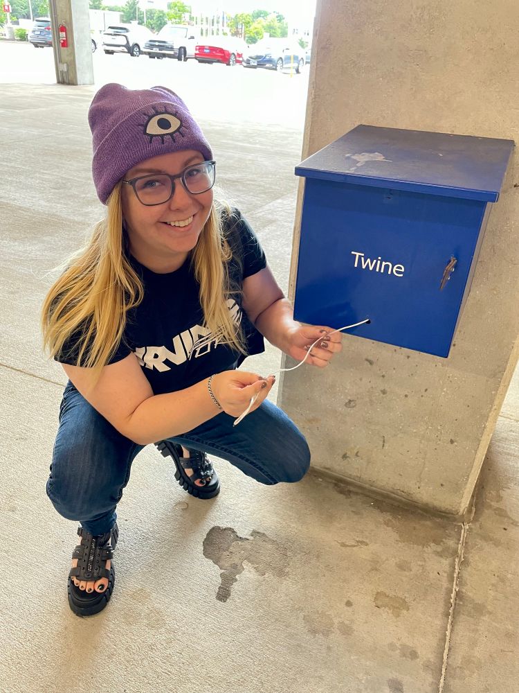 Kelsey holding a piece of twine, making a terrible joke 