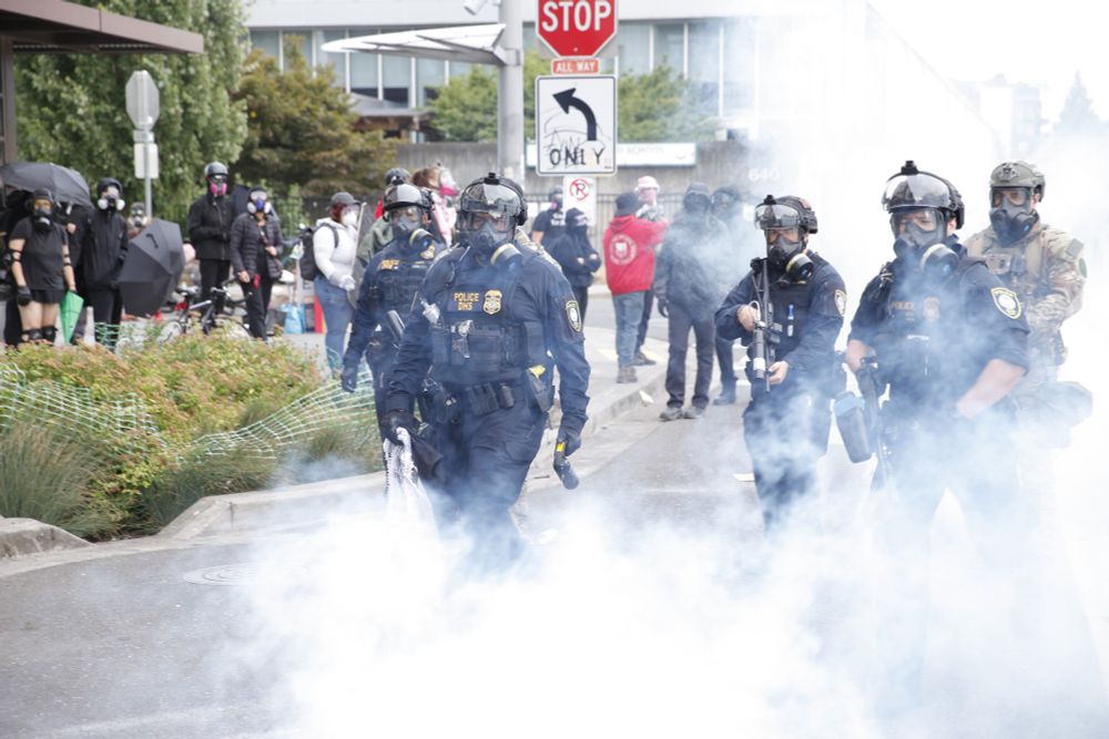DHS officers carry bear mace through tear gas dispersing peaceful protesters in Portland, OR