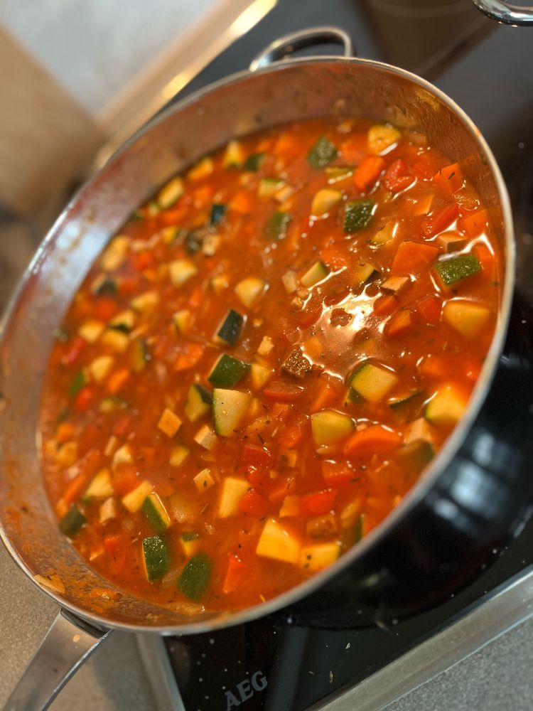 In der Pfanne sind die Zutaten mit passierten Tomaten, Wasser, Salz und Pfeffer ca. 20 Minuten gekocht. Das Essen ist fertig.