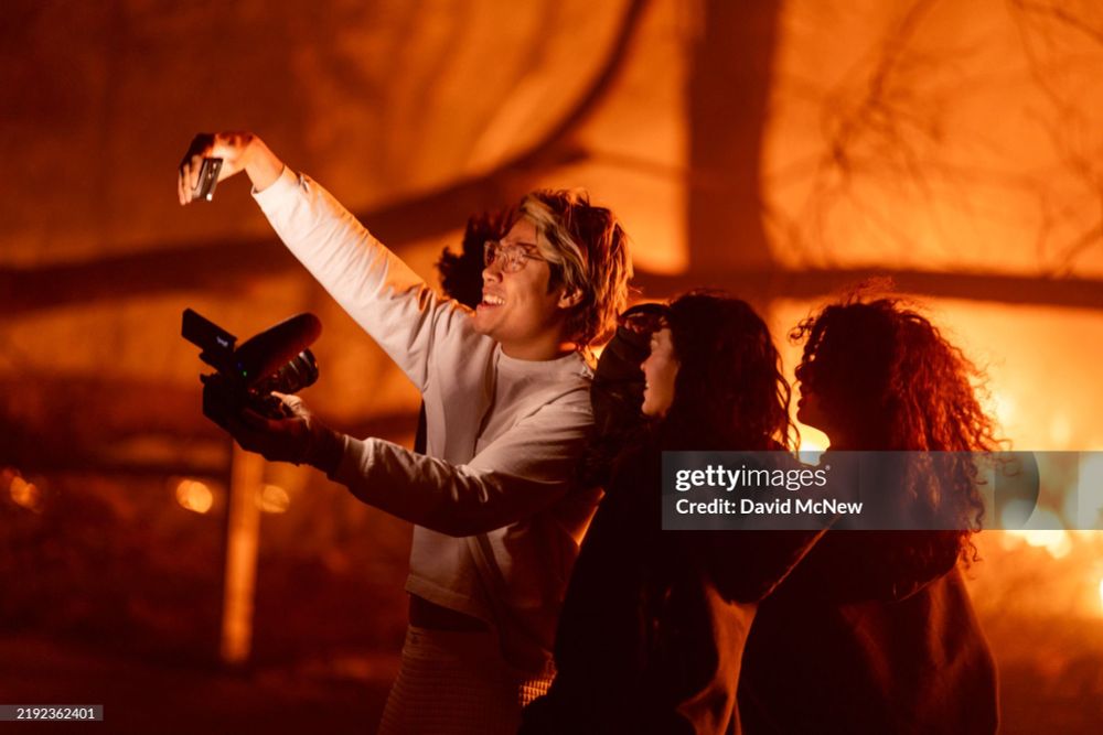 People enter an evacuation zone to take selfie photos and videos near burning homes at the Eaton Fire on January 7, 2025 in Pasadena, California. A powerful Santa Ana wind event has dramatically raised the danger of wind-driven wildfires such as the dangerous and destructive Palisades Fire near Santa Monica. The strong winds also forced President Joe Biden to cancel his plan to travel between Los Angeles and Riverside, California. (Photo by David McNew/Getty Images)