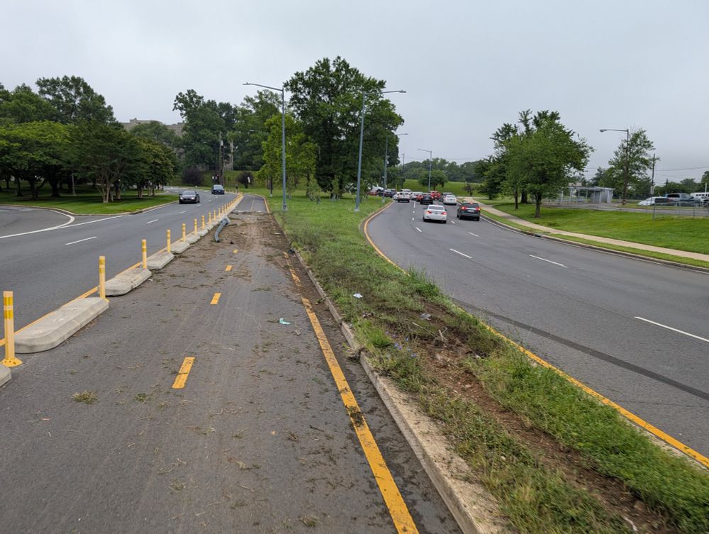 Skid marks and tire marks on the grass of car that drove into the protected bicycle path.