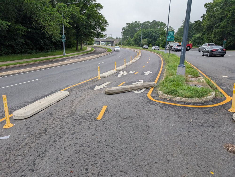 Large concrete curb segment, protecting the bicycle path, knocked into the middle of the protected bicycle path.