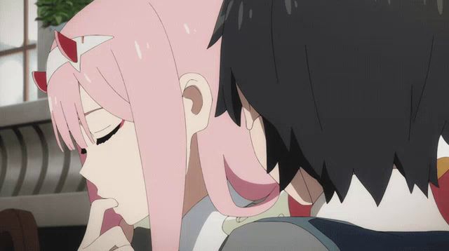 a girl with pink hair and horns is kissing a boy with black hair