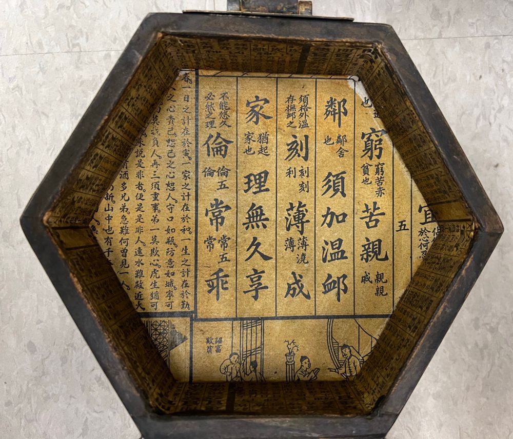 Interior of vintage women’s box with Chinese characters written on the top and bottom of the interior.