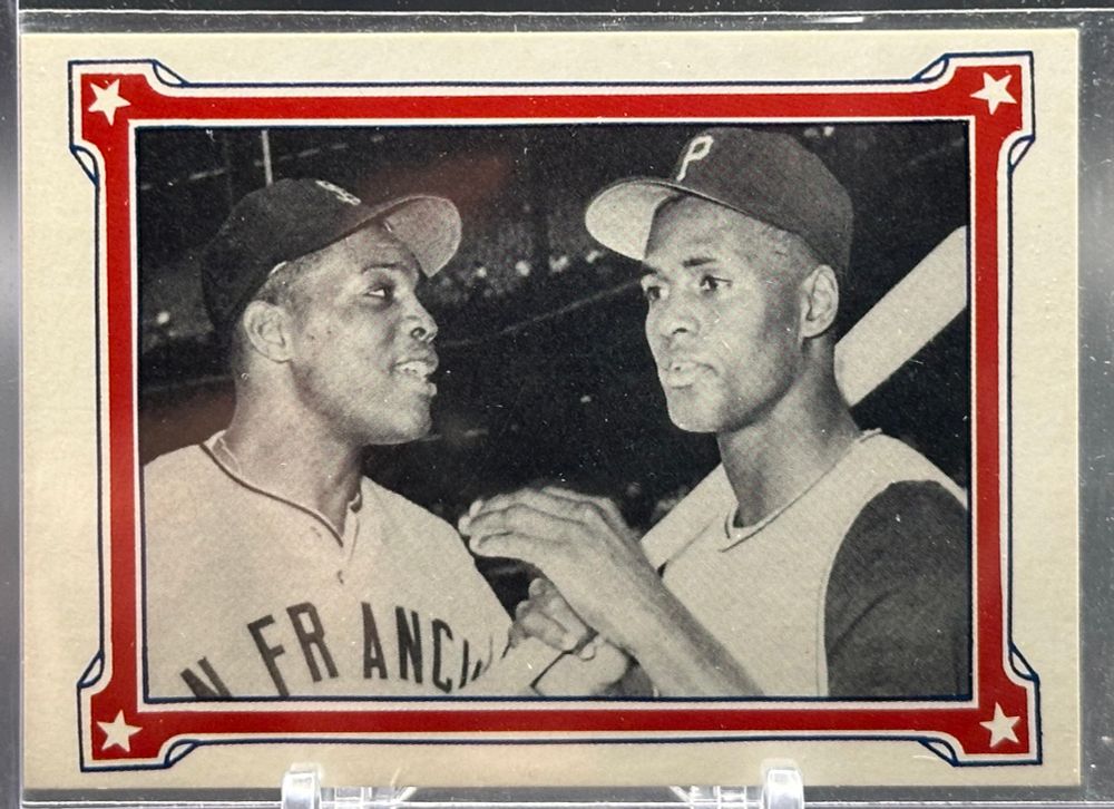 1984 ASA The Willie Mays Story 3,000 Hitters baseball card. Black and white picture of Willie and Roberto Clemente together talking, Mays in his SF Giants uniform and Clemente in his Pirates uniform holding his bat.