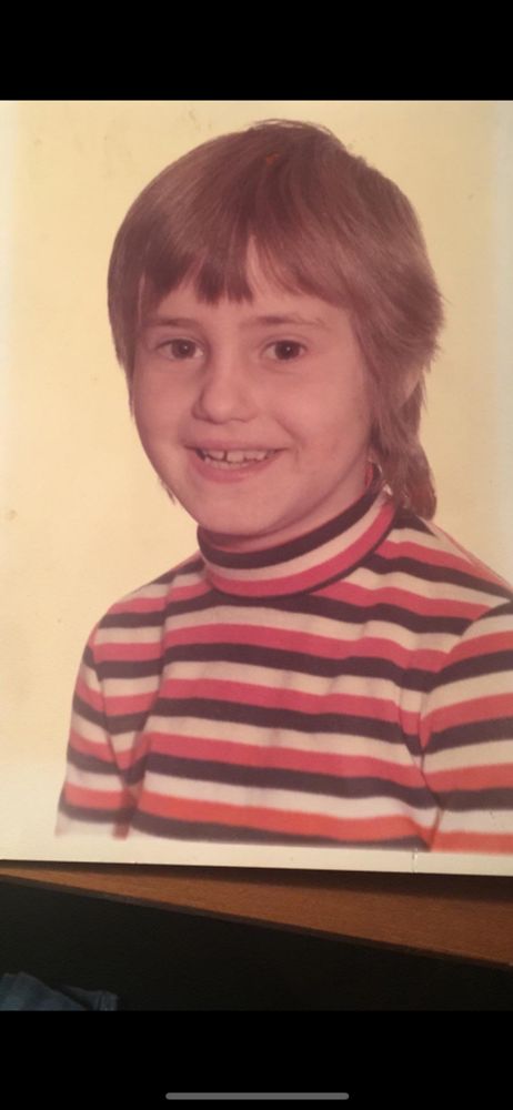 Ein Kind trägt einen rot-weiß-schwarzen Pullover 