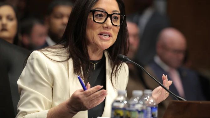 Lori Chavez-DeRemer, in a photo from a Senate confirmation hearing, appearing with straight hair, no obvious extensions, no apparent filler, and “natural-looking” makeup.