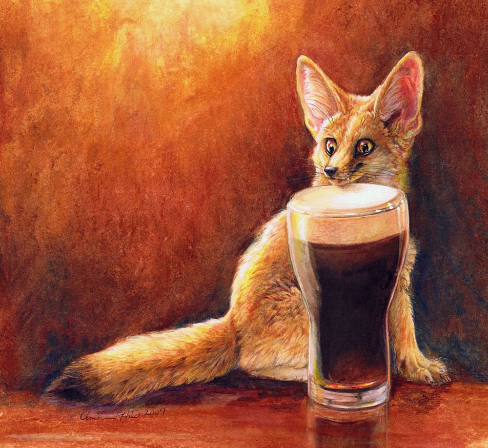 A fennec fox sits with his chin hovering above tall pint of dark beer with a creamy head of foam. His expression indicates he may have had some already, but he’s clearly exciting for a little bit more. The lighting and background is warm golden browns. 