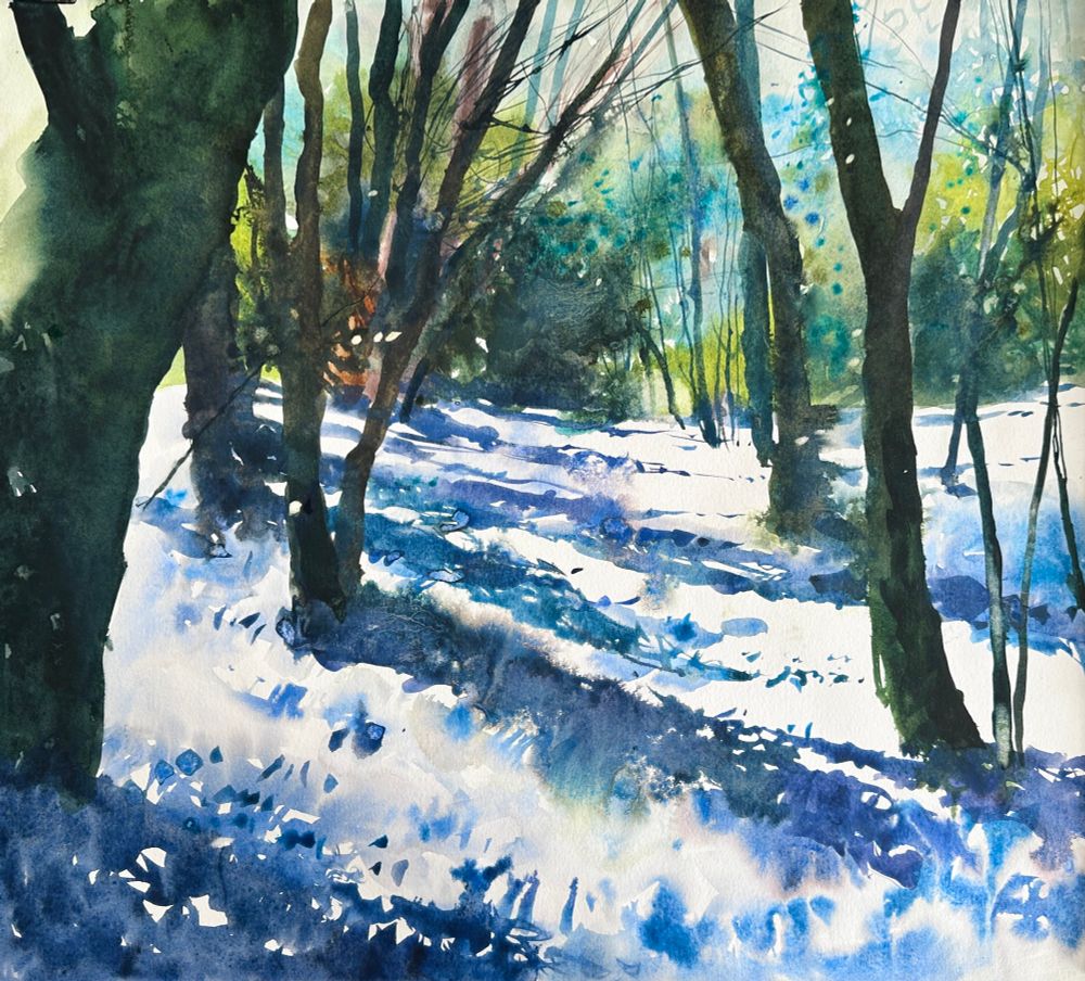 Watercolour painting looking through a woodland to a green distance in spring light. Blue shadows dance diagonally across the woodland floor which I’ve left as white paper to represent the sunlight.