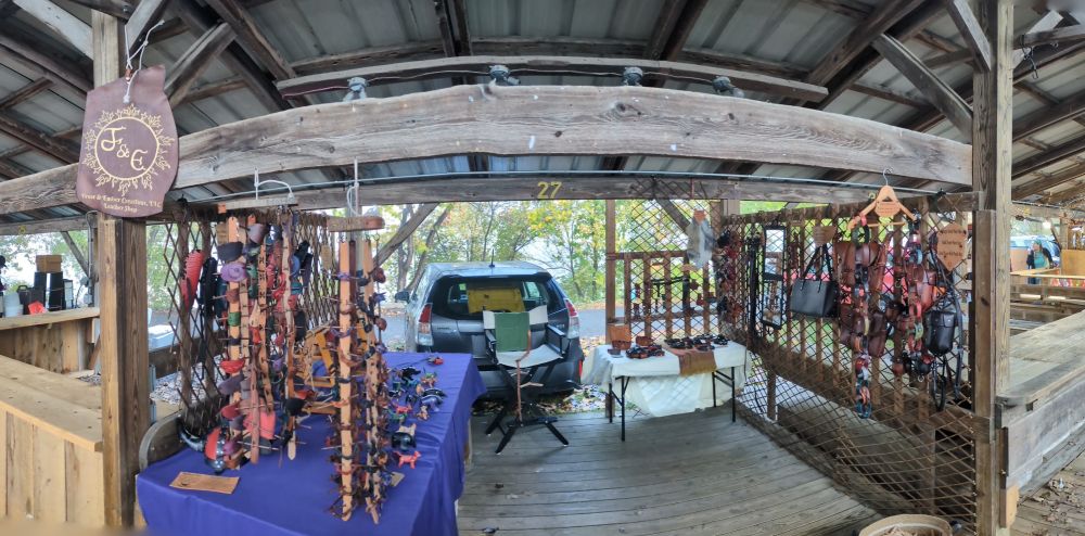A wooden booth full of leather goods in a variety of forms. Bags on the right side, leather animals on the left. 
