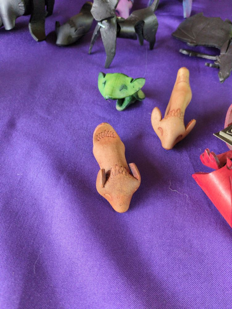 Three leather hamsters, two brown, one green - the green one is sitting up.