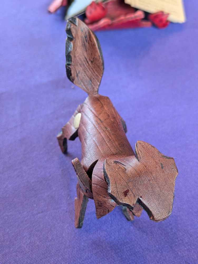A small leather wolf, printed to look like carved wood.