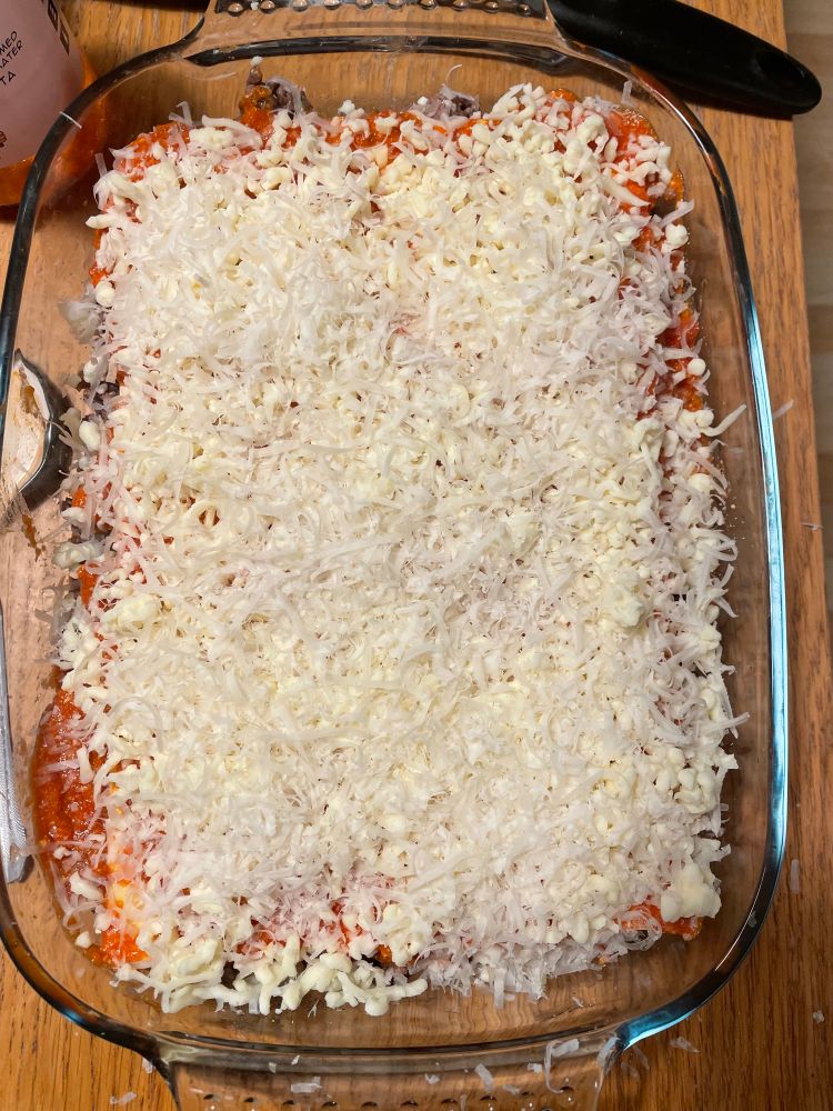 A glass dish of unbaked lasagna 
